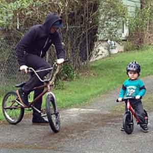Adam Deemer riding a bike with a small child