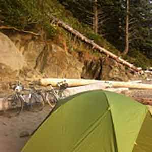 carolyn eaton's tent on a beach next to touring bikes